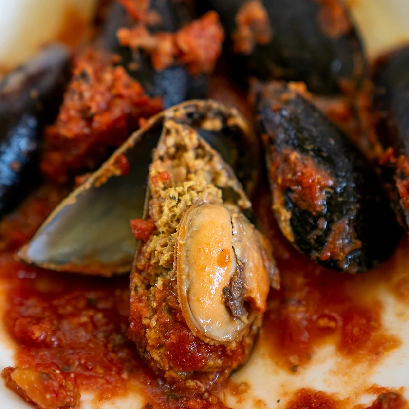 Moules farcies nappées d'une sauce tomate relevée au piment